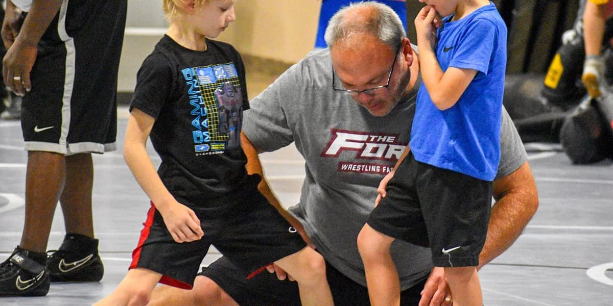 Coach teaching young wrestlers